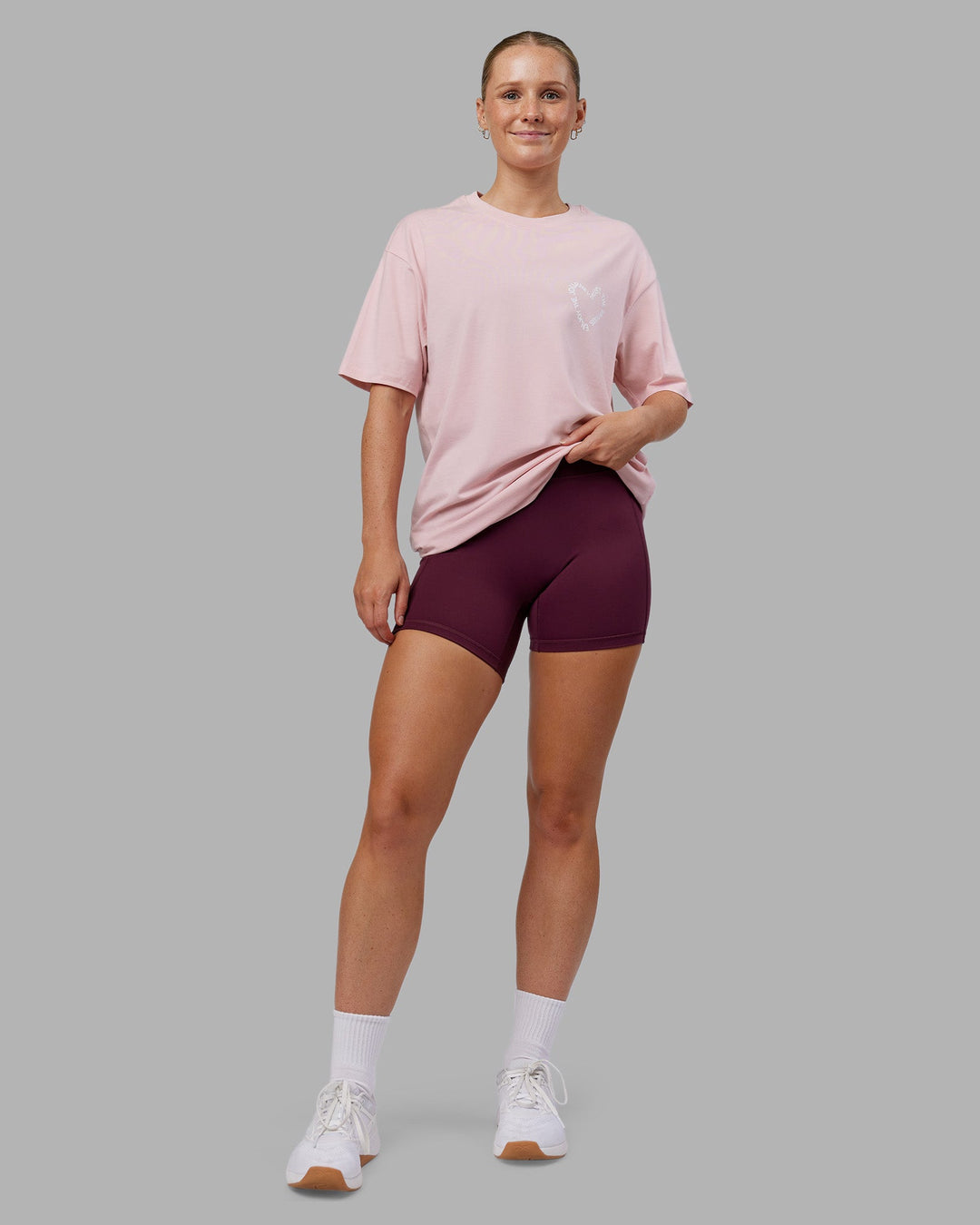 Woman wearing Love The Process FLXCotton Oversize Tee - Petal Pink-White | Model:Neve | Size:XS