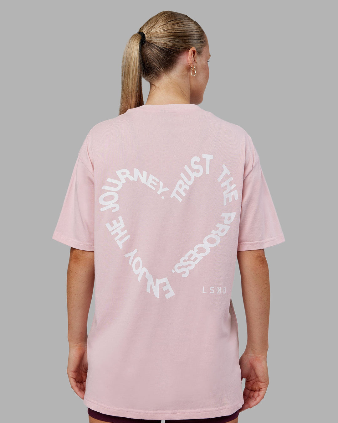 Woman wearing Love The Process FLXCotton Oversize Tee - Petal Pink-White | Model:Neve | Size:XS