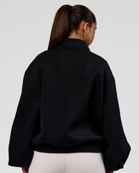 Woman wearing Luxe ZeroCrease Spacer Half Zip - Black | Model:Sophia | Size:XS