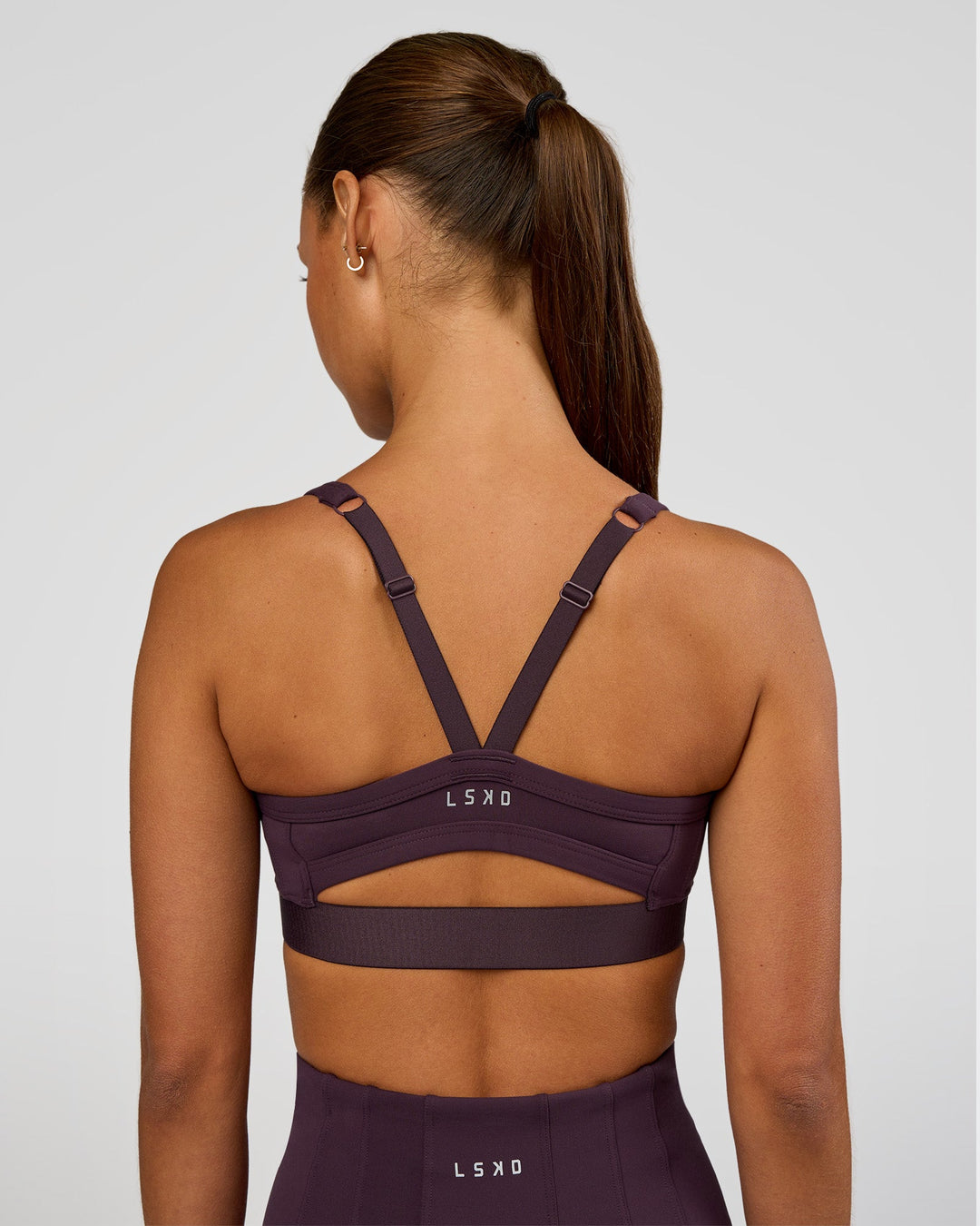 Woman wearing Momentum Corset Sports Bra - Midnight Plum | Model:Brylee | Size:XS