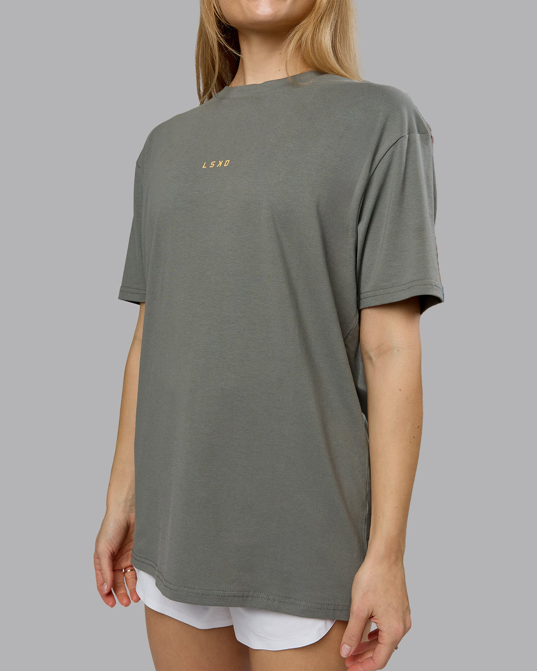 Woman wearing On Repeat FLXCotton Oversized Tee - Graphite-Warm Apricot | Model:Emilie | Size:XS