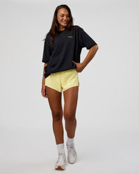 Woman wearing RUN CLUB FLXCotton Tee Oversize - Black-Yellow Fizz | Model:Kirstyn | Size:XS