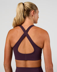 Woman wearing Stamina Sports Bra - Midnight Plum | Set:true | Angle:back | Model:Emelia | Size:XS