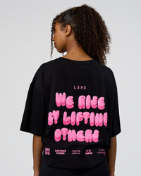 Woman wearing Together We Rise FLXCotton Oversized Tee - Black-Candy Pink | Model:Jordan | Size:XS