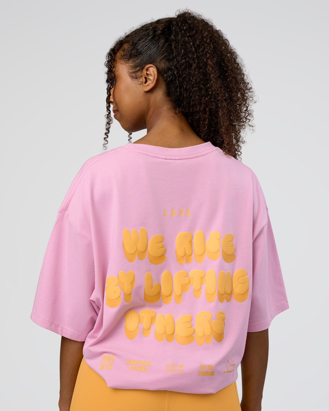 Woman wearing Together We Rise FLXCotton Oversized Tee - Bubblegum-Warm Apricot | Model:Jordan | Size:L