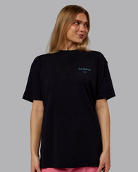 Woman wearing Trust The Process 2.0 FLXCotton Tee Oversize - Black-Blue Atoll | Model:Emilie | Size:XS