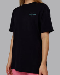 Woman wearing Trust The Process 2.0 FLXCotton Tee Oversize - Black-Blue Atoll | Model:Emilie | Size:XS