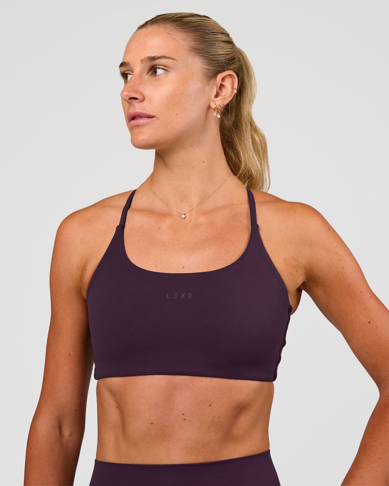 Woman wearing Twist Sports Bra - Midnight Plum | Model:Emelia | Size:XS