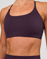 Woman wearing Twist Sports Bra - Midnight Plum | Model:Emelia | Size:XS