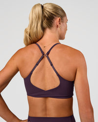Woman wearing Twist Sports Bra - Midnight Plum | Model:Emelia | Size:XS