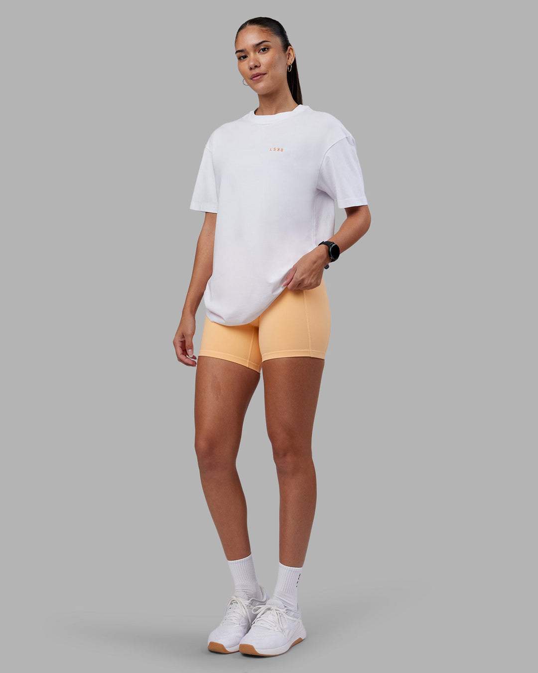 Woman wearing Enjoy the Journey Value Series FLXCotton Tee Oversize - White-Vibrant Orange | Model:Rhiley | Size:XS