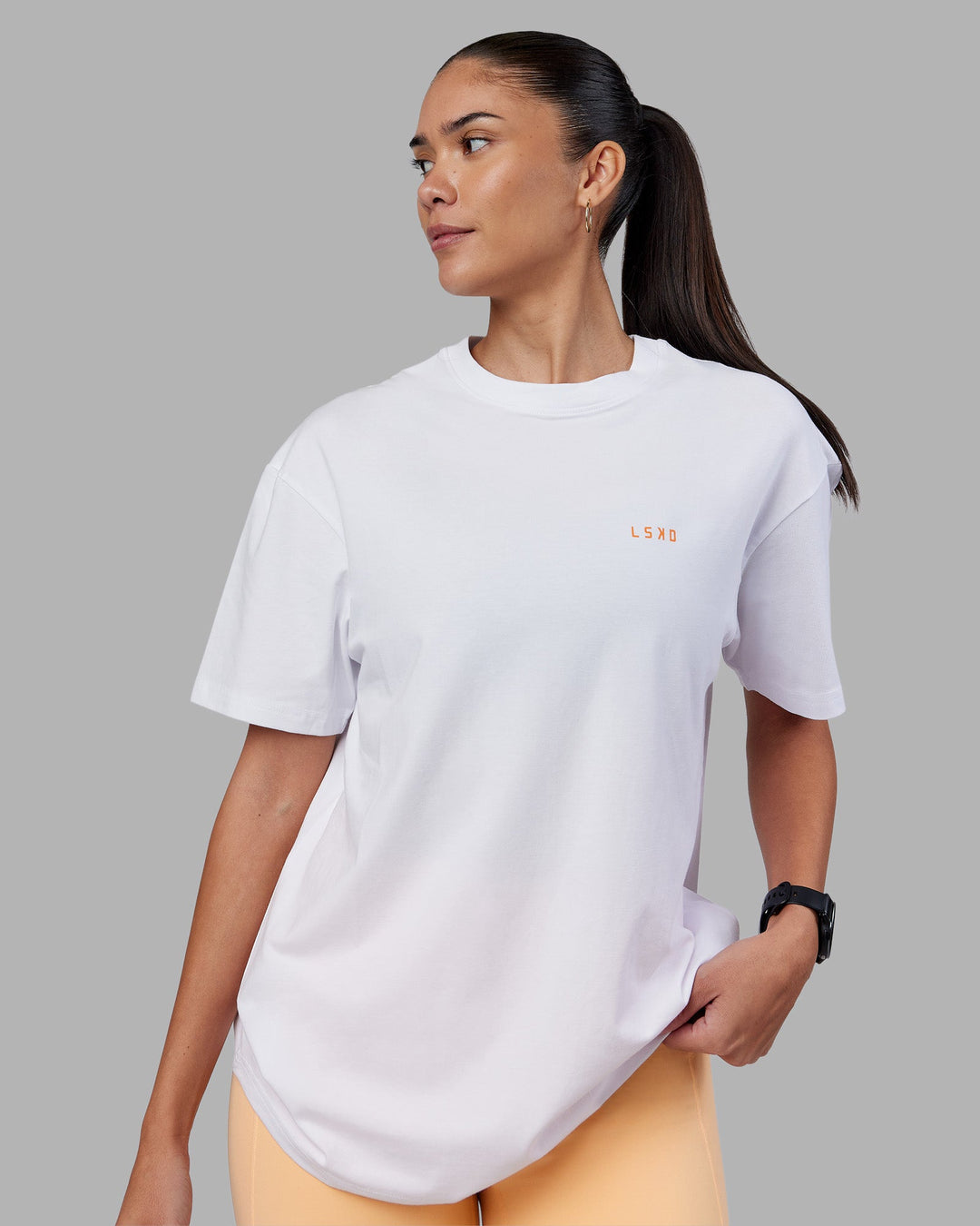 Woman wearing Enjoy the Journey Value Series FLXCotton Tee Oversize - White-Vibrant Orange | Model:Rhiley | Size:XS