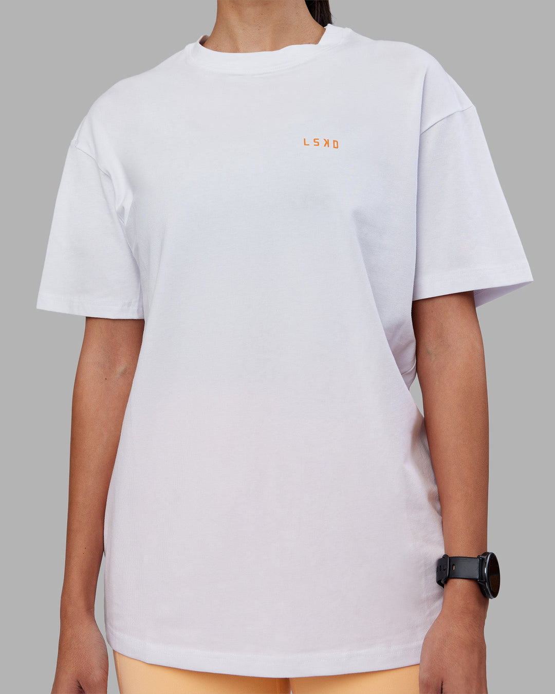 Woman wearing Enjoy the Journey Value Series FLXCotton Tee Oversize - White-Vibrant Orange | Model:Rhiley | Size:XS