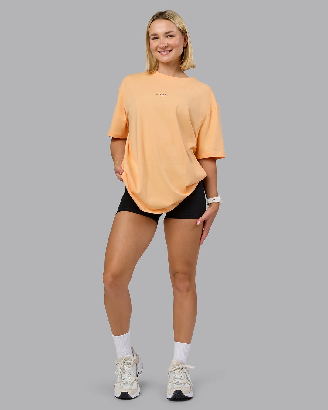 Woman wearing On Repeat FLXCotton Oversized Tee - Peach Fuzz-White | Model:Halle | Size:XS