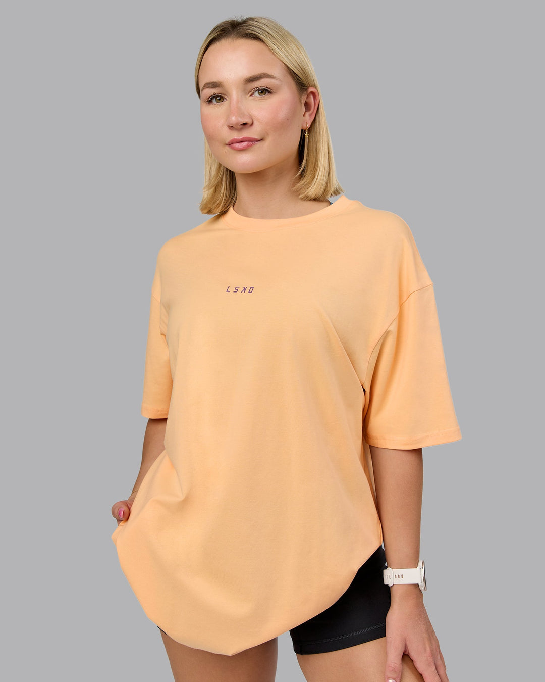 Woman wearing On Repeat FLXCotton Oversized Tee - Peach Fuzz-White | Model:Halle | Size:XS