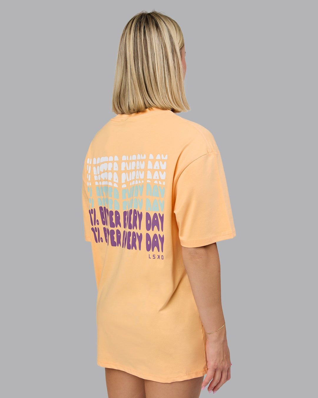 Woman wearing On Repeat FLXCotton Oversized Tee - Peach Fuzz-White | Model:Halle | Size:XS