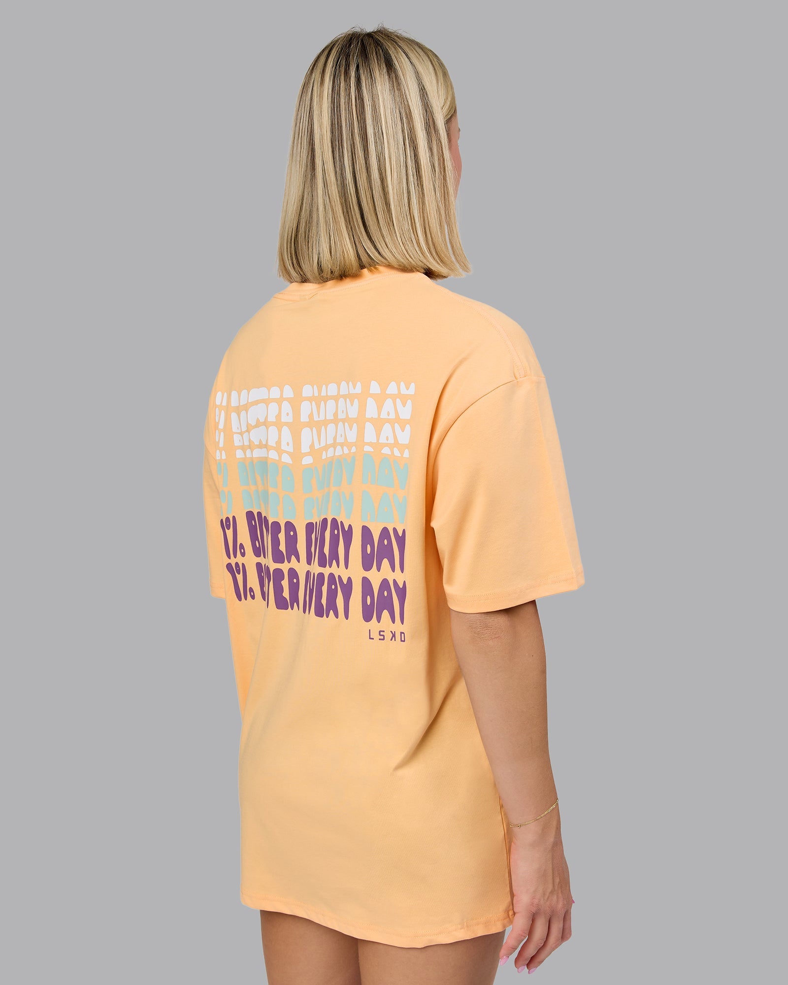 Woman wearing On Repeat FLXCotton Oversized Tee - Peach Fuzz-White | Model:Halle | Size:XS