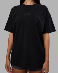 Woman wearing Variation Heavyweight FLXCotton Oversized Tee - Black-Black | Model:Rhiley | Size:XS