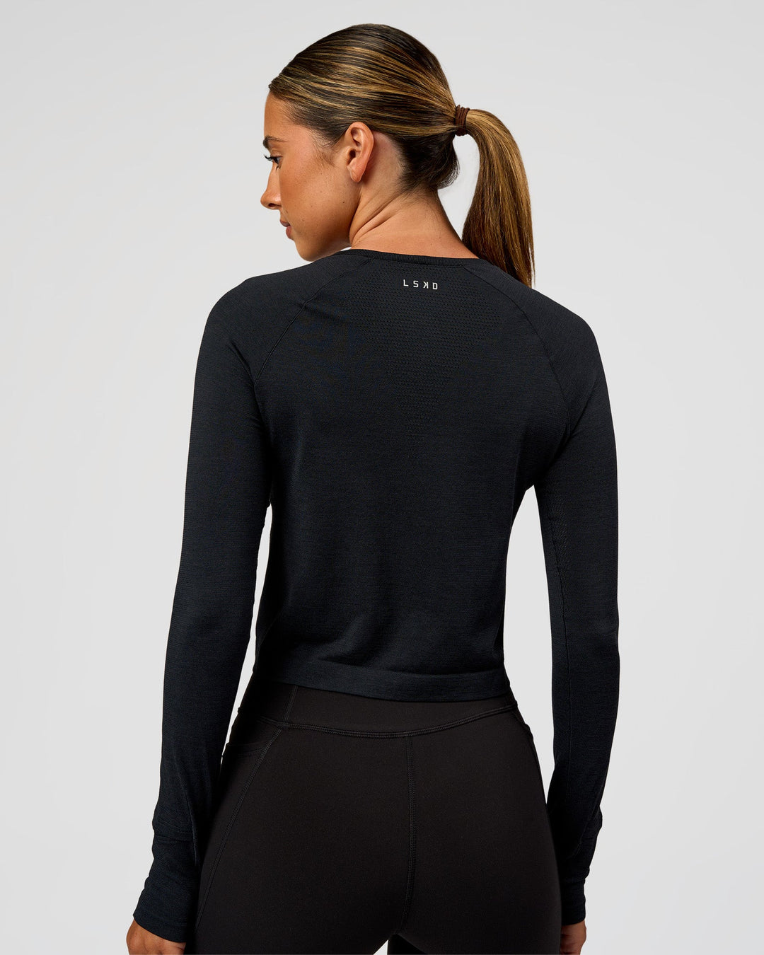 Woman wearing AeroFLX+ Seamless Long Sleeve Skimmer Tee - Black Marl | Model:Charli | Size:XS