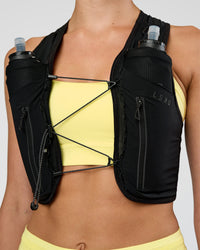 Woman wearing Pace Running Vest - Black-Reflective | Model:Evie | Size:XS/S