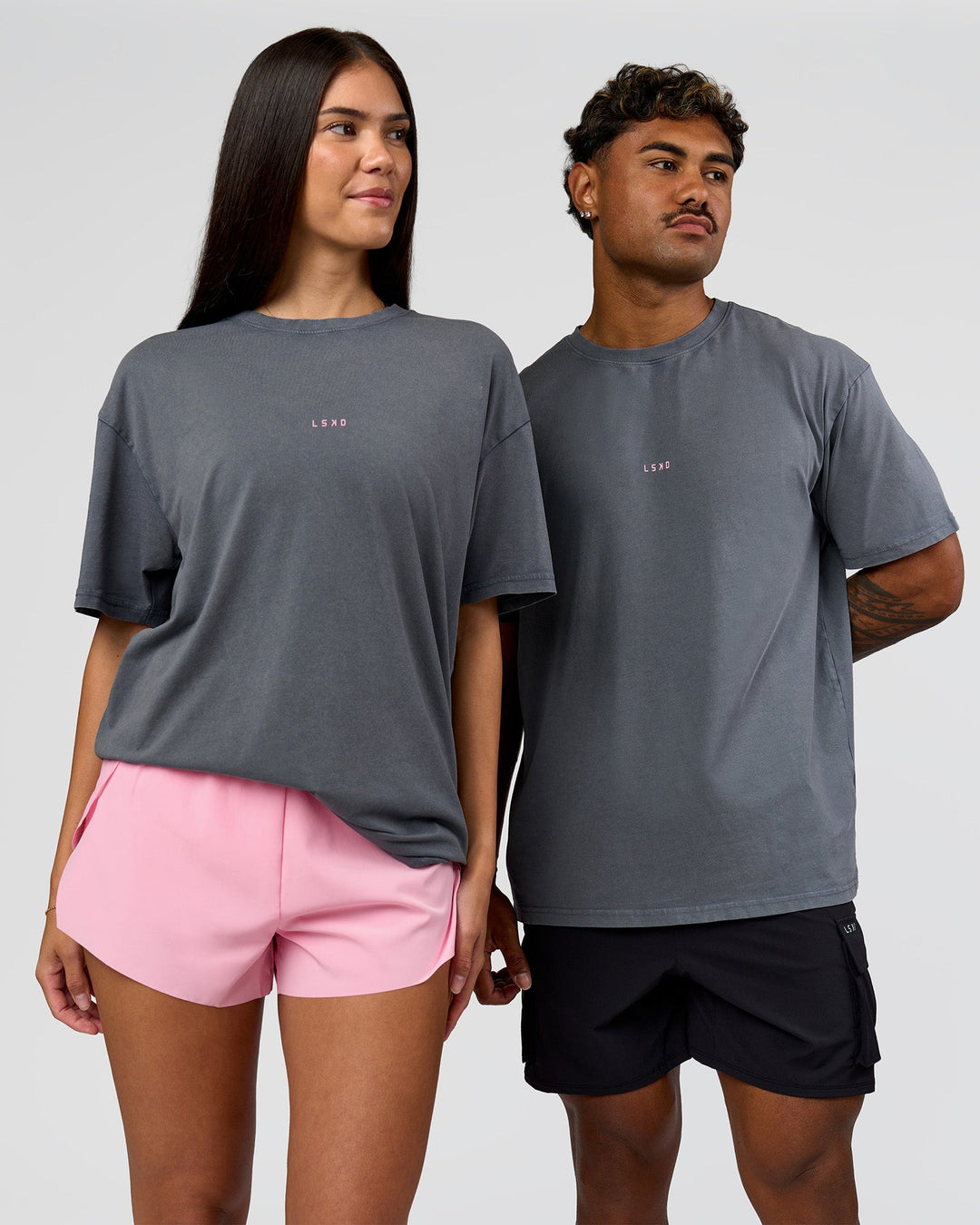 Duo wearing Built On Values FLXCotton Oversized Tee - Dark Storm Washed-Pink Rose | Model:Xav | Size:L | Model:Rhiley | Size:XS