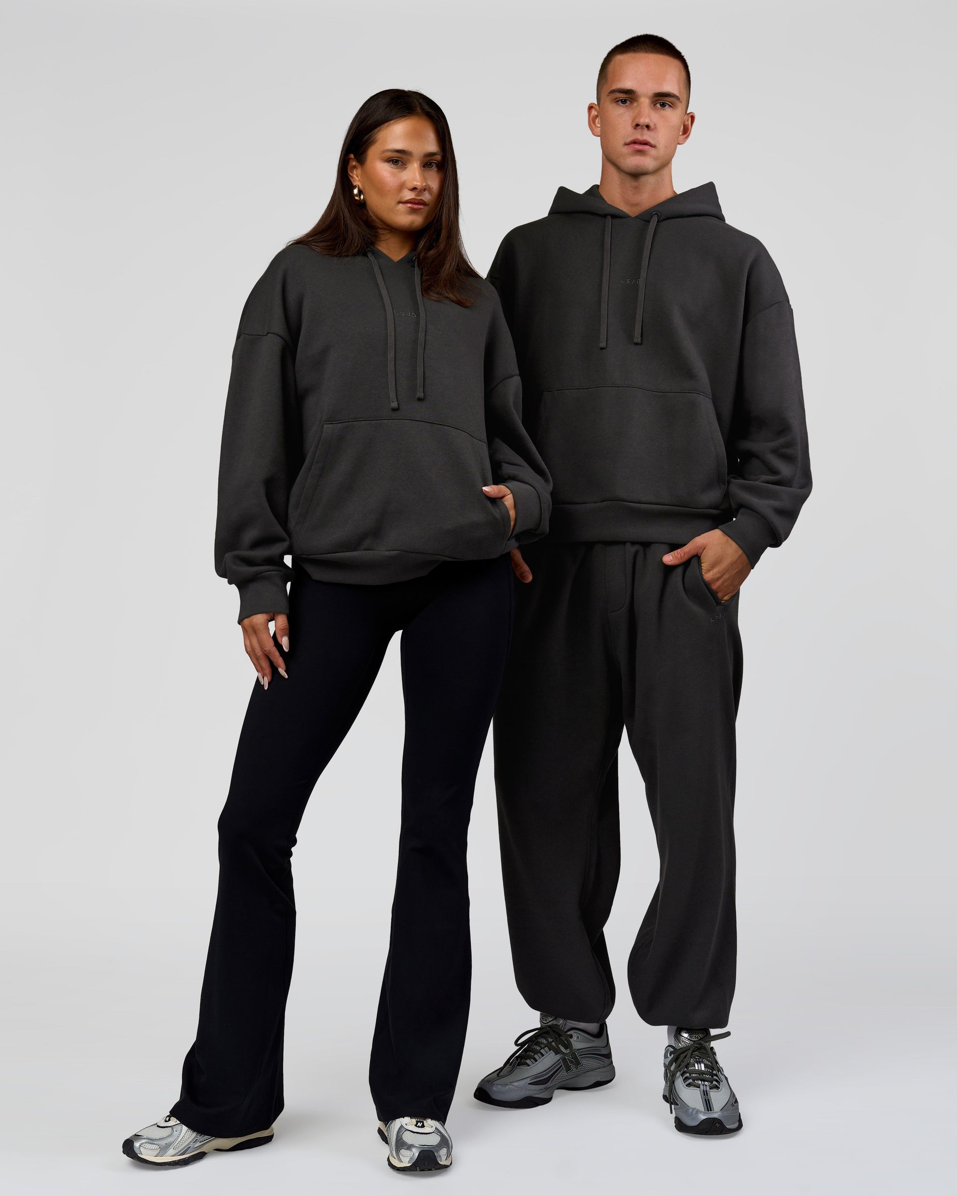 Duo wearing Base Oversized DC Hoodie - Onyx | Model:Albert | Size:M | Model:Bianca | Size:XS