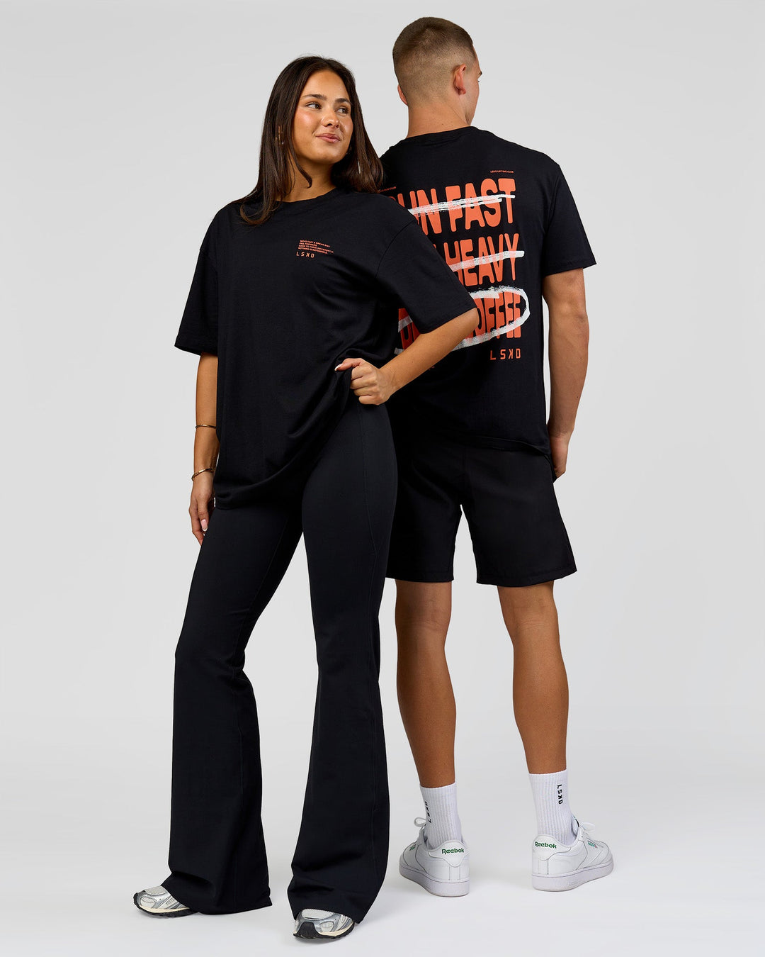 Duo wearing Coffee Run FLXCotton Oversized Tee - Black-Ultra Orange | Model:Albert | Size:M | Model:Bianca | Size:XS - view 3