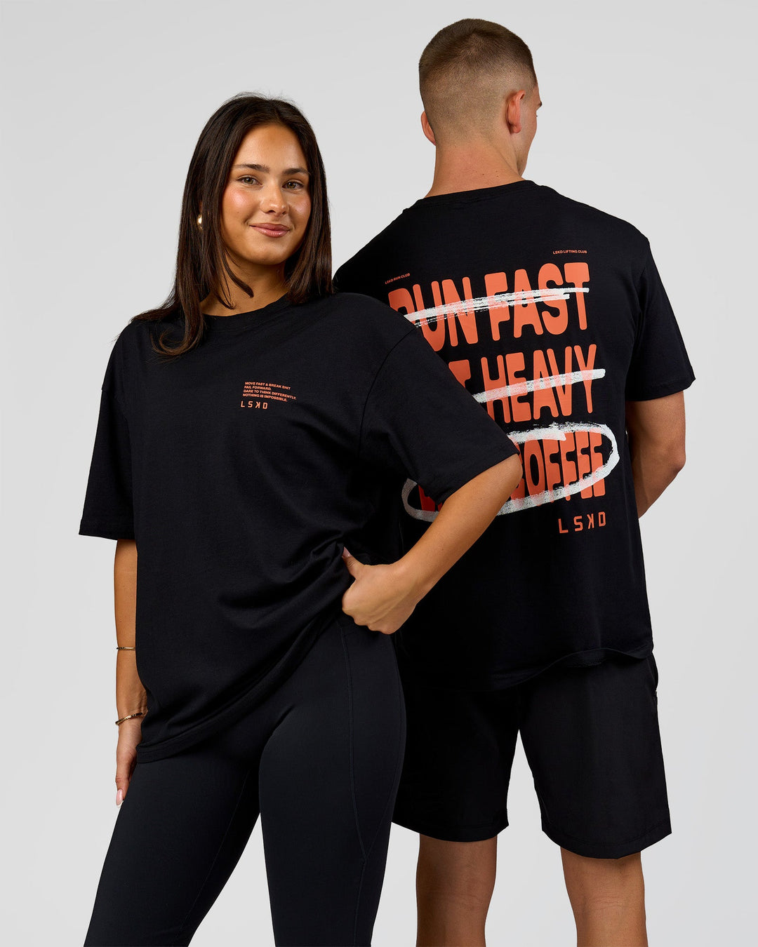 Duo wearing Coffee Run FLXCotton Oversized Tee - Black-Ultra Orange | Model:Albert | Size:M | Model:Bianca | Size:XS - view 1