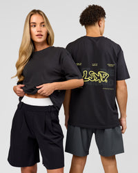 Duo wearing Benchmark FLXCotton Oversized Tee - Onyx-Yellow Fizz | Model:Issy | Size:XS | Model:Leandro | Size:M | Thumbnail Index: 0