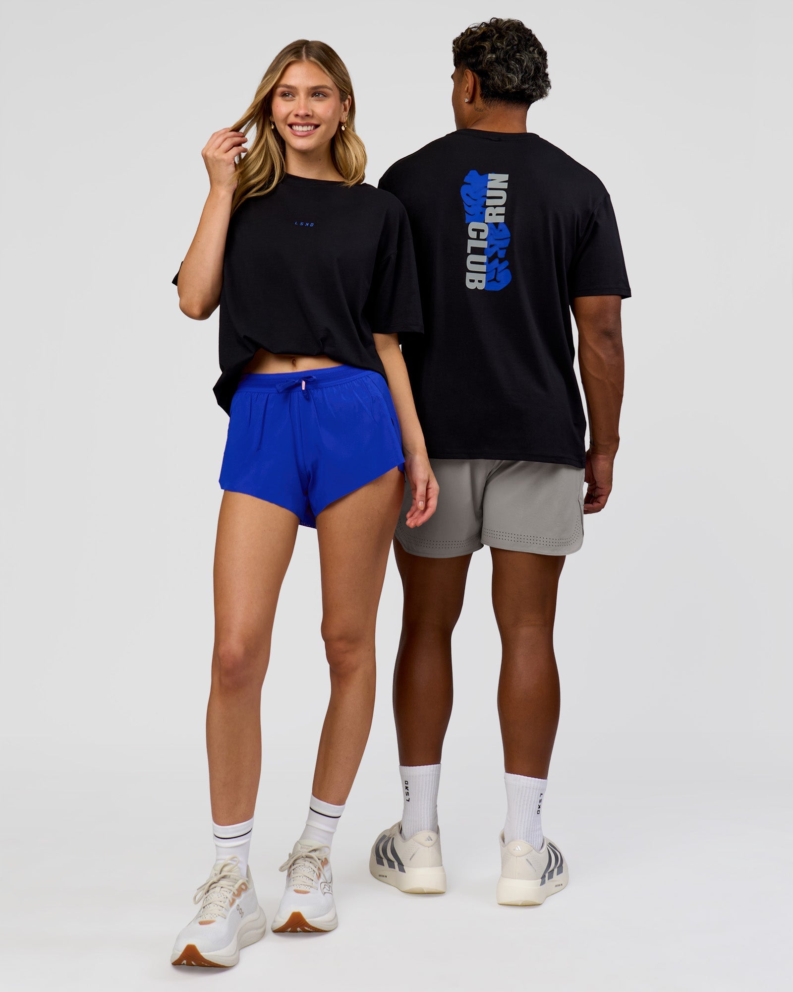 Duo wearing Run Club Elevate FLXCotton Oversized Tee - Black-Electric Indigo | Model:Leilani | Size:XS | Model:Xav | Size:L