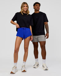 Duo wearing Run Club Elevate FLXCotton Oversized Tee - Black-Electric Indigo | Model:Leilani | Size:XS | Model:Xav | Size:L