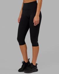 Woman wearing O.G. Fusion Ultra High-Rise 3/4 Legging Pockets - Black | Model:Milly | Size:S