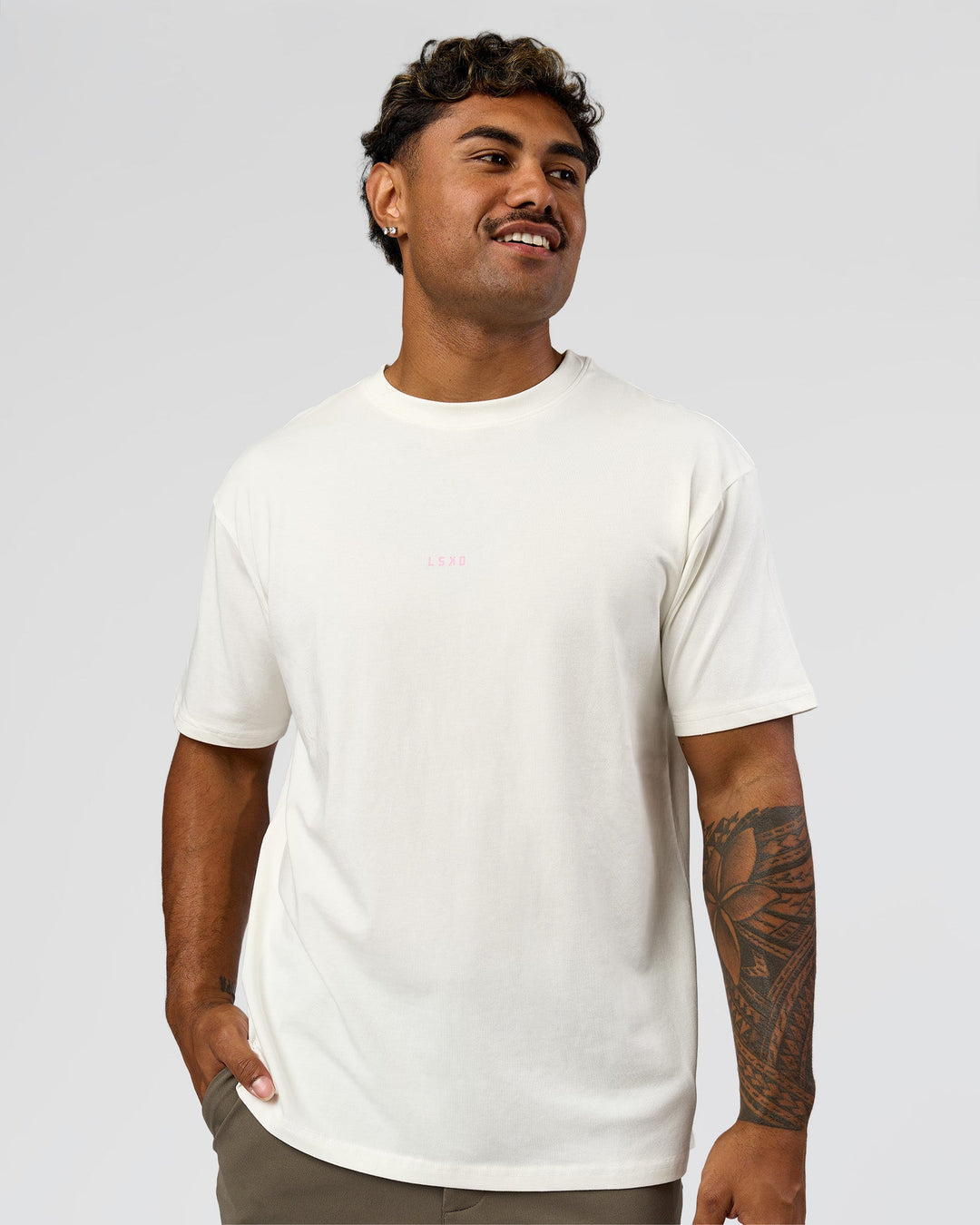 Man wearing Built On Values FLXCotton Oversized Tee - Off White-Pink Rose | Model:Xav | Size:L