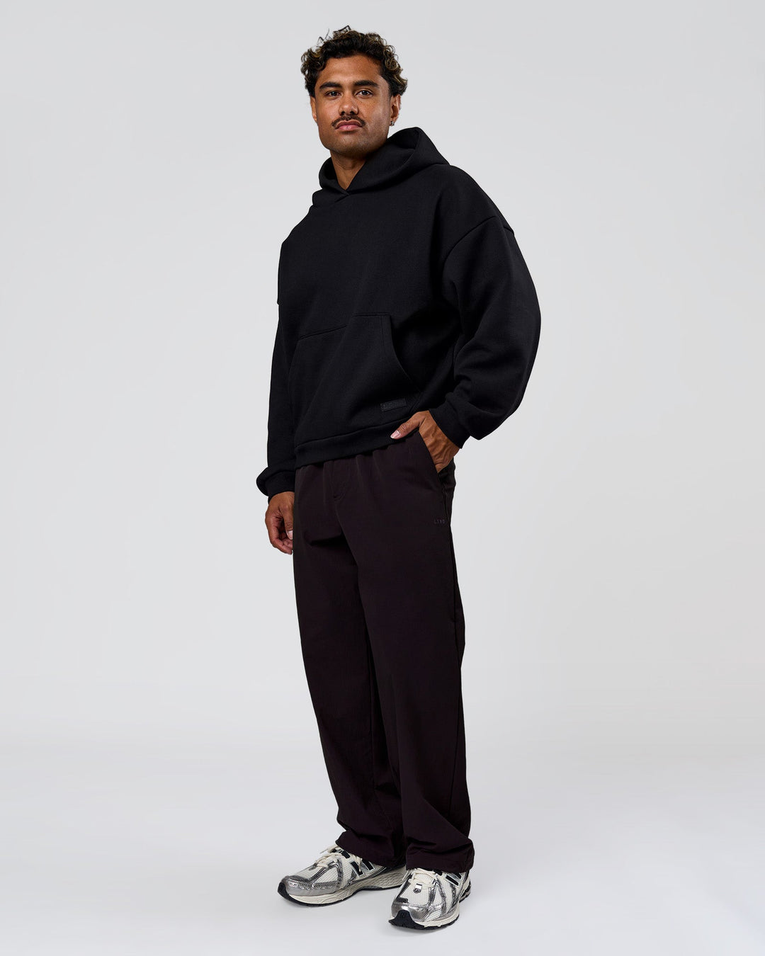 Man wearing Tonal Legacy Boxy Hoodie - Black-Black | Model:Xav | Size:L - view 10