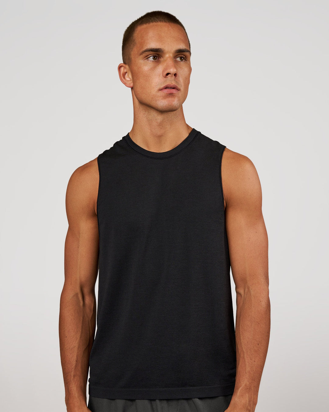 Man wearing AeroFLX+ Seamless Muscle Tank - Black Marl | Model:Albert | Size:M - view 1