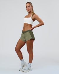 Woman wearing Accelerate 3" Mid-Rise Running Short - Pure Olive-Fog | Model:Xs | Size:ISSY | Thumbnail Index: 2