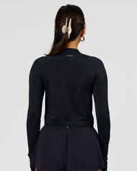 Woman wearing AeroFLX+ Long Sleeve Skimmer Half Zip - Black Marl | Model:Bianca | Size:S