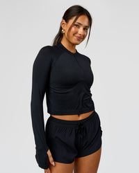 Woman wearing AeroFLX+ Long Sleeve Skimmer Half Zip - Black Marl | Model:Bianca | Size:S