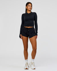 Woman wearing AeroFLX+ Long Sleeve Skimmer Half Zip - Black Marl | Model:Bianca | Size:S