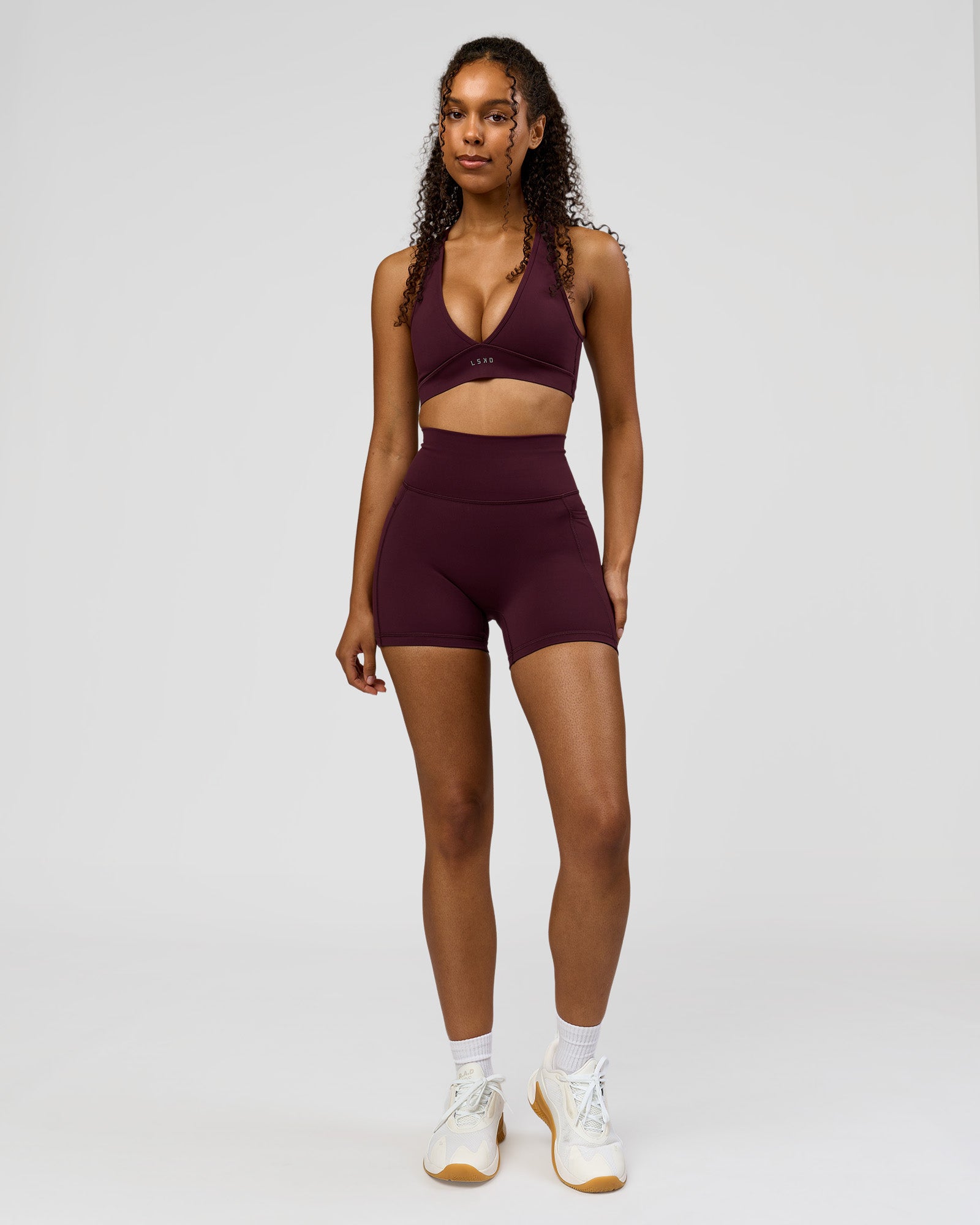 Woman wearing Fusion Ultra High-Rise 4" Short Pockets - Cherry Lacquer | Model:Jordan | Size:S