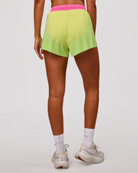 Woman wearing Accelerate 3" High-Rise Running Short - Lime Glo-Sugar Plum | Model:Charli | Size:XS | Thumbnail Index: 2