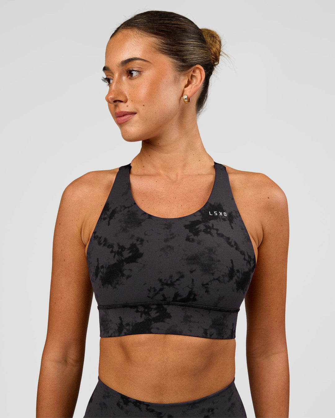 Woman wearing Accelerate Split Strap Sports Bra - Black Tie Dye | Model:Charli | Size:XS - view 2