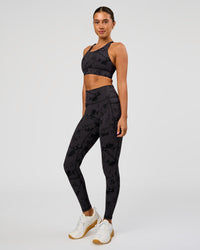 Woman wearing Accelerate Split Strap Sports Bra - Black Tie Dye | Model:Charli | Size:XS | Thumbnail Index: 2