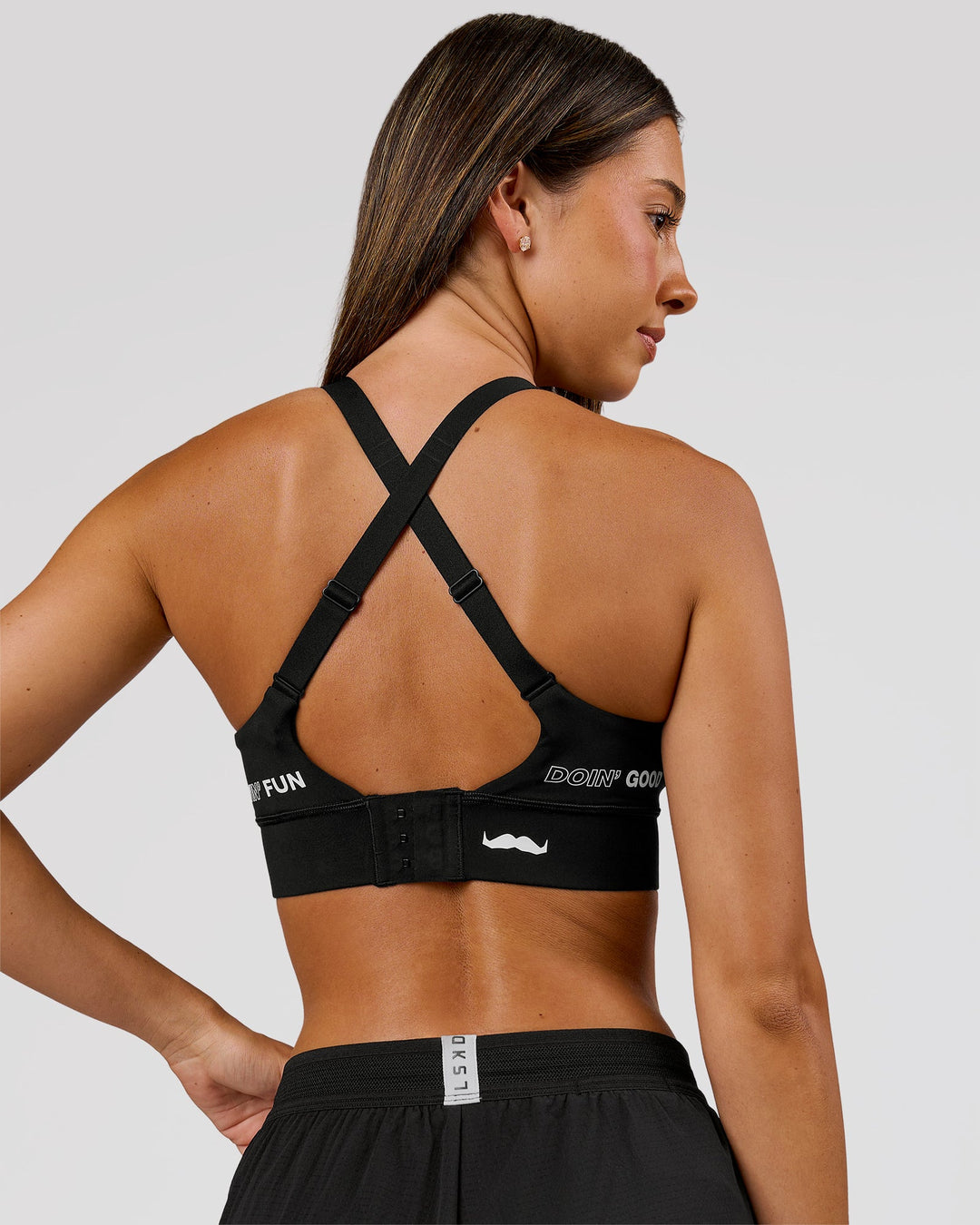Woman wearing Movember x LSKD Accelerate Sports Bra - Black | Model:Charli | Size:XS - view 4