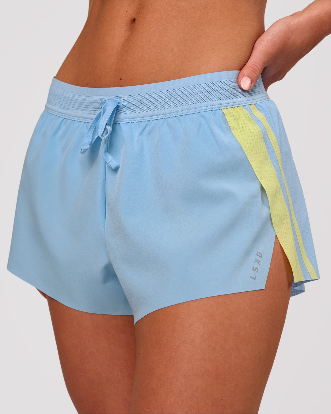 Woman wearing Accelerate 3" Force Mid-Rise Running Short - Open Air-Lemon | Model:Issy | Size:XS - view 1