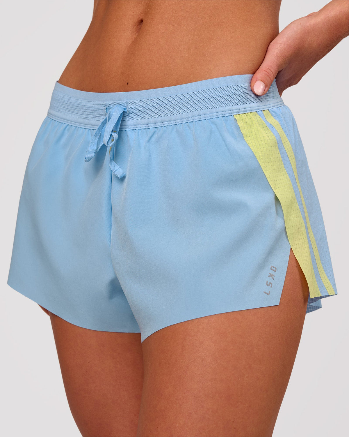 Woman wearing Accelerate 3" Force Mid-Rise Running Short - Open Air-Lemon | Model:Issy | Size:XS