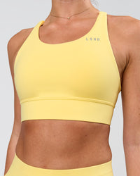 Woman wearing Accelerate Sports Bra - Lemon | Model:Issy | Size:XS | Thumbnail Index: 2