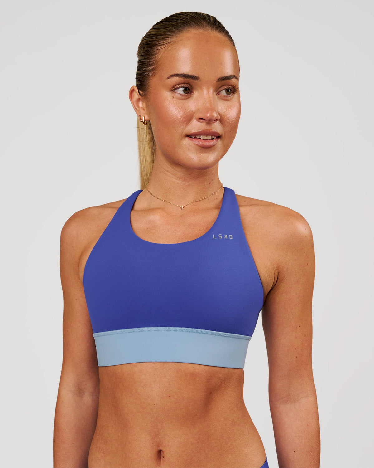 Woman wearing Accelerate Sports Bra - Power Cobalt-Open Air | Model:Issy | Size:XS