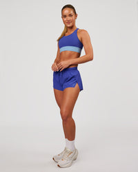 Woman wearing Accelerate Sports Bra - Power Cobalt-Open Air | Model:Issy | Size:XS | Thumbnail Index: 4