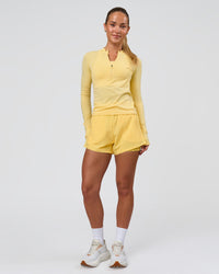 Woman wearing AeroFLX+ Long Sleeve Half Zip - Lemon/Lemon | Model:Issy | Size:XS | Thumbnail Index: 1